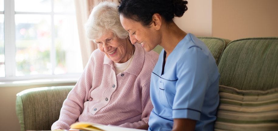 Pflegerin unterstützt eine Seniorin zuhause