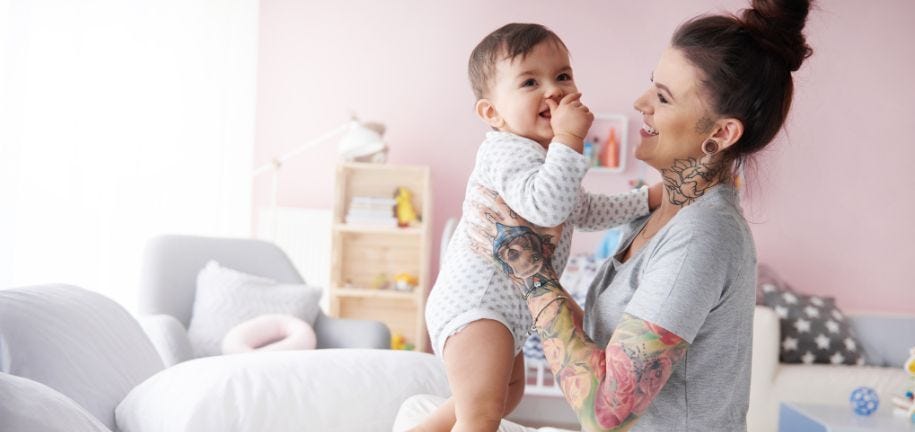 Junge Frau sieht ihr Baby nach ihrer Weiterbildung nach der Elternzeit