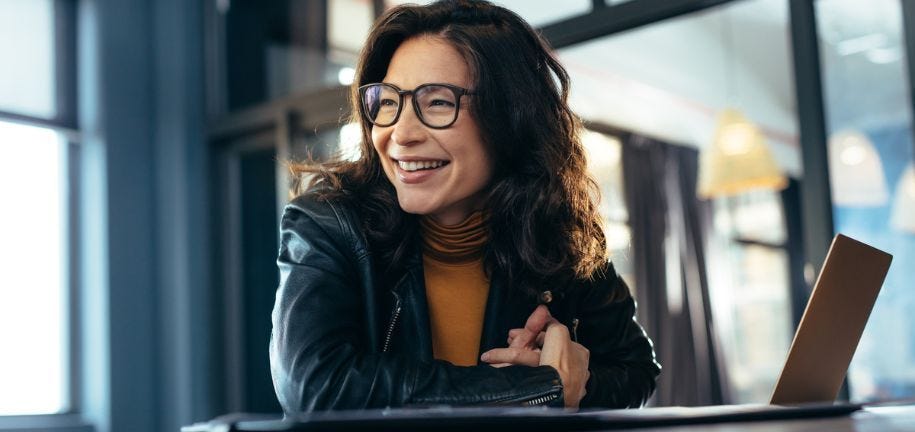 Eine Frau im mittleren Alter lernt in einem Onlinekurs etwas über Bürokommunikation