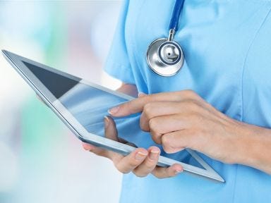 Eine Pflegefachkraft hält ein Tablet in der Hand 