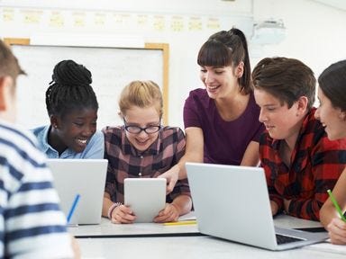 Sie möchten mit Menschen arbeiten und Wissen weitergeben? Dann ist eine Weiterbildung in der Pädagogik genau das Richtige für Sie.  Pädagogin hilft einem Mädchen beim Schreiben