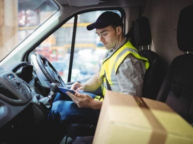 Botenfahrer prüft Lieferung im Fahrzeug