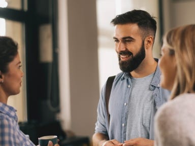 Eine diverse Gruppe unterhält sich ausgelassen auf einem Flur