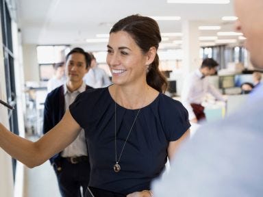 Vermittlerin der Arbeitagentur zeigt einem Arbeisuchenden den Newsletter der TÜV Rheinland Akademie