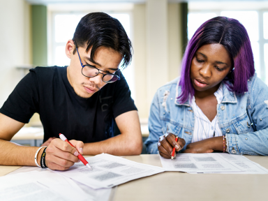 Zwei Jugendliche bei einem Sprachkurs in einem Klassenraum