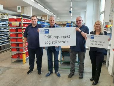 Mitarbeiter aus dem Trainingscenter und der IHK stehen in der Lagerwerkstatt in Dresden