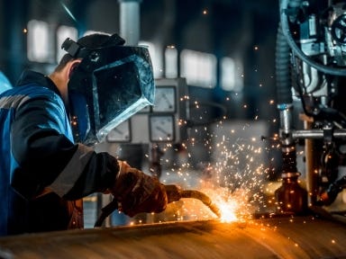 Schwei&szlig;er bei der Arbeit an einer Metallkonstruktion in einer industriellen Fertigung
