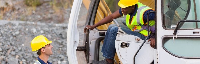 Baumaschinenfahrer in Abstimmung mit seinem Kollegen. Baumaschinenfahrer in Abstimmung mit seinem Kollegen.