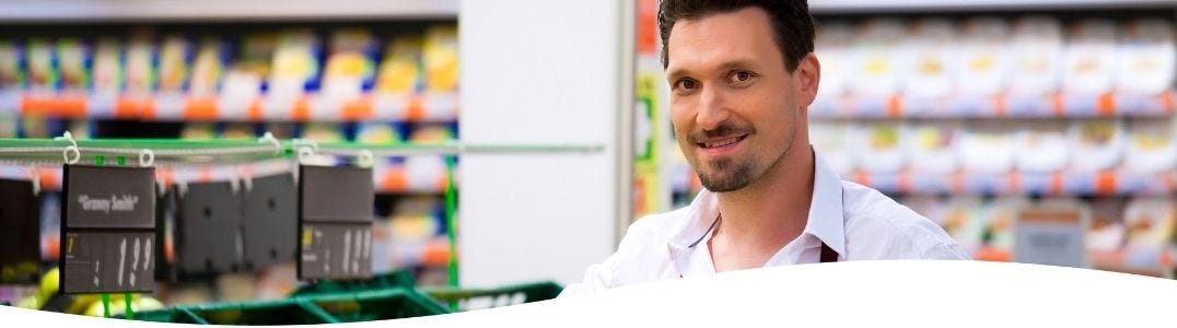 Verkäufer organisiert das Warensortimient in einem Supermarkt