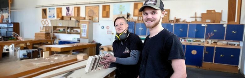 Umschüler stehen in Berliner Ausbildungstischlerei vor Werkbank