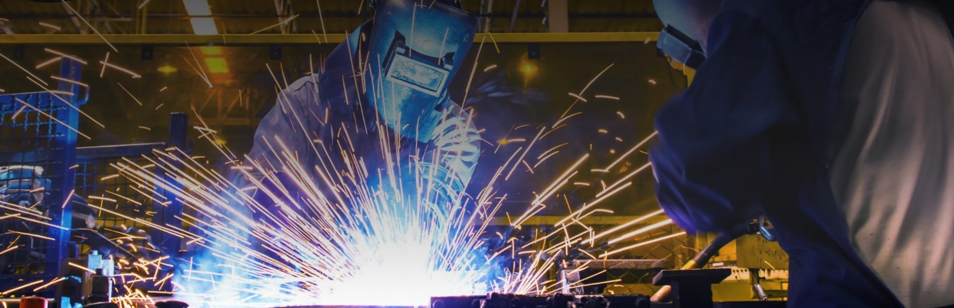 Lernen Sie das Schweißen in unseren modernen Schweißkursstätten. 2 Männer lernen Schweißen in der TÜV Rheinland Akademie