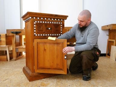 Ein Tischler präsentiert sein Gesellenstück, eine kleine Kommode