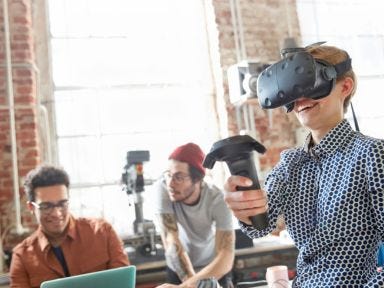 Gruppe Jungen mit VR-Brille in einem hellen Raum, die moderne Technologien entdecken