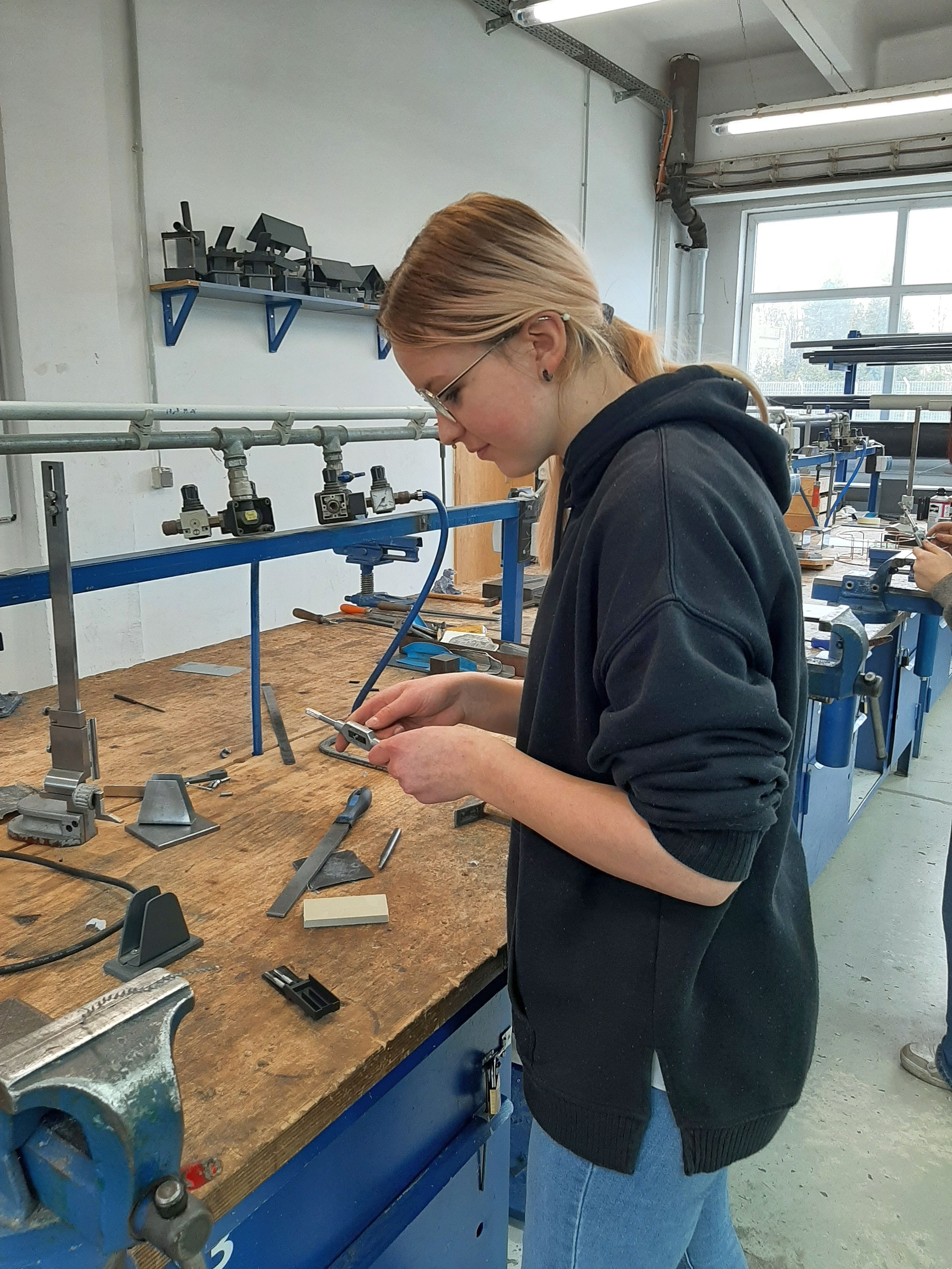 Eine Schülerin bearbeitet ein Metallstück in der Senftenberger Werkstatt