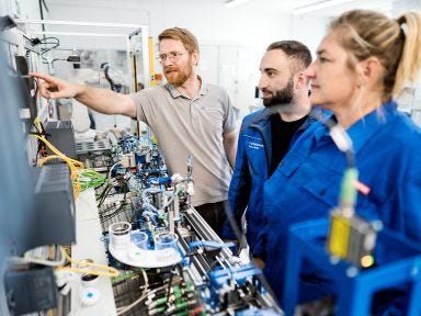 Der Ausbilder erklärt den Verbundschülern die Bedienelemente der Automatisierungsanlage 