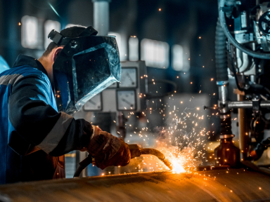 Schwei&szlig;er bei der Fertigung einer Metallkonstruktion in der Werkhalle